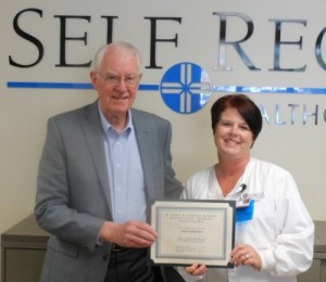 Self Regional's former CEO John Heydel presents Julie Culbertson with the M. John and Drenda Heydel Respiratory Therapy scholarship.